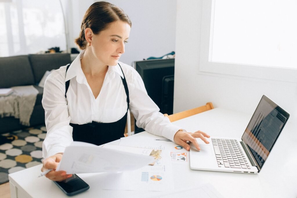Pessoas trabalhando com laptops e celulares, com ícones de relatórios e WhatsApp flutuando, representando automação de vendas.