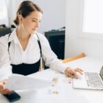 Pessoas trabalhando com laptops e celulares, com ícones de relatórios e WhatsApp flutuando, representando automação de vendas.