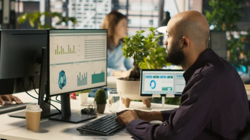 Pessoas trabalhando em laptops com gráficos de vendas e ícones de CRM, representando a gestão de clientes em PMEs.