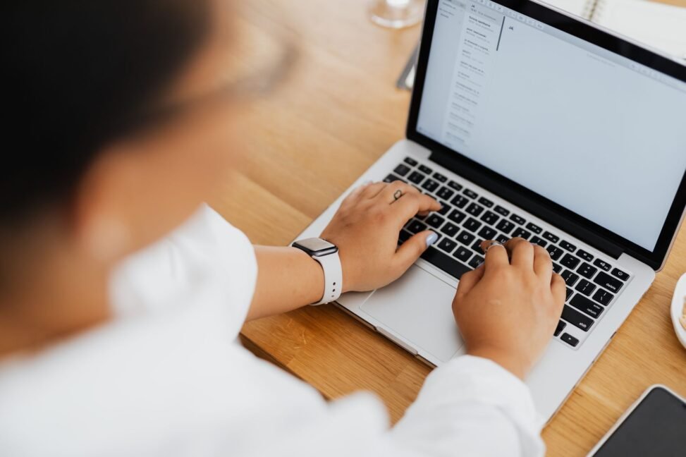 Pessoa digitando em um laptop com ícones de email e gráficos de crescimento ao redor, simbolizando comunicação B2B eficaz.